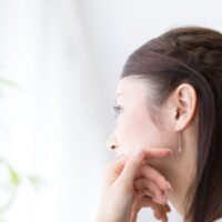 JCBプラチナカードの評判が気になる30代女性が窓の外を見つめる横顔