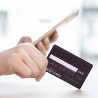 スマートフォンで決済するためにクレジットカードを操作している手元の様子