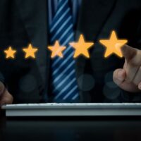 クレジットカードの評価を表す5つ星を選択するビジネスマンのイメージ画像｜セゾンカードの評判と口コミに関する視覚素材