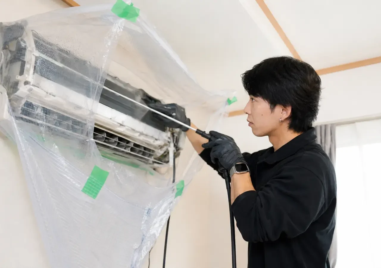 周辺を養生してエアコン内部を洗浄するClear Linkスタッフ