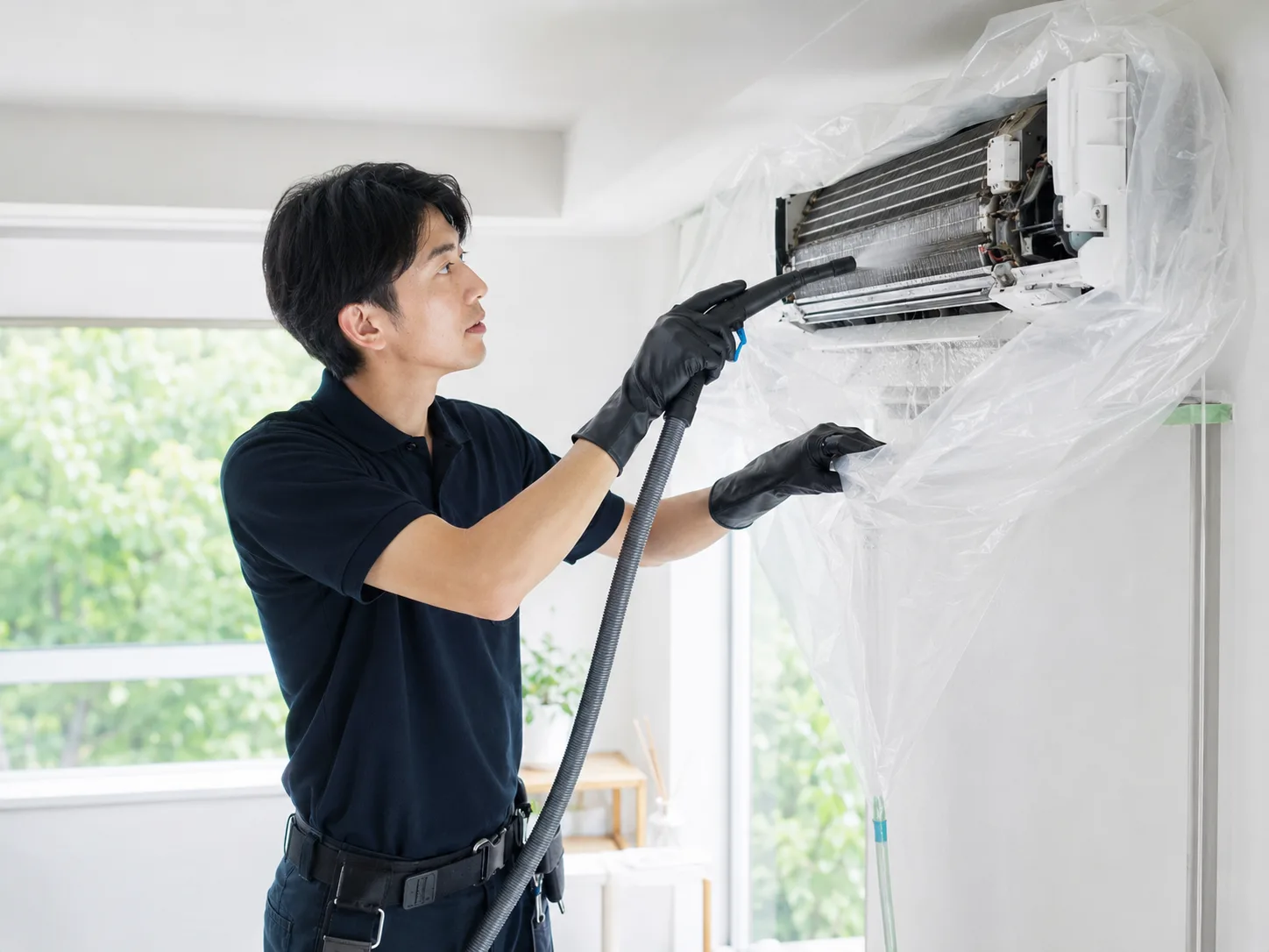 養生を行いエアコンの熱交換器と内部を洗浄するClear Linkスタッフ