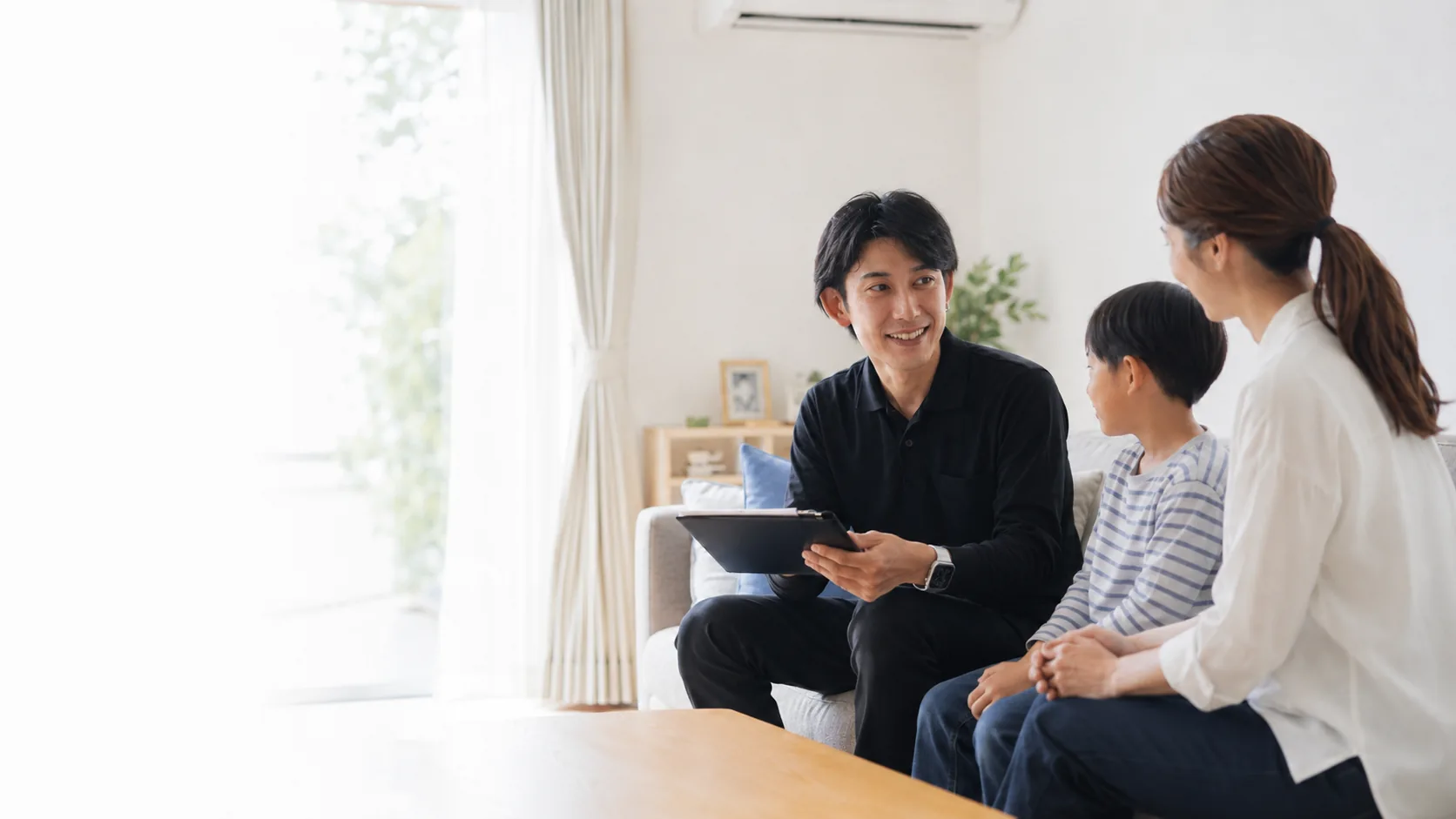 明るいリビングで母親と子どもの相談に対応するClear Link代表の草場優