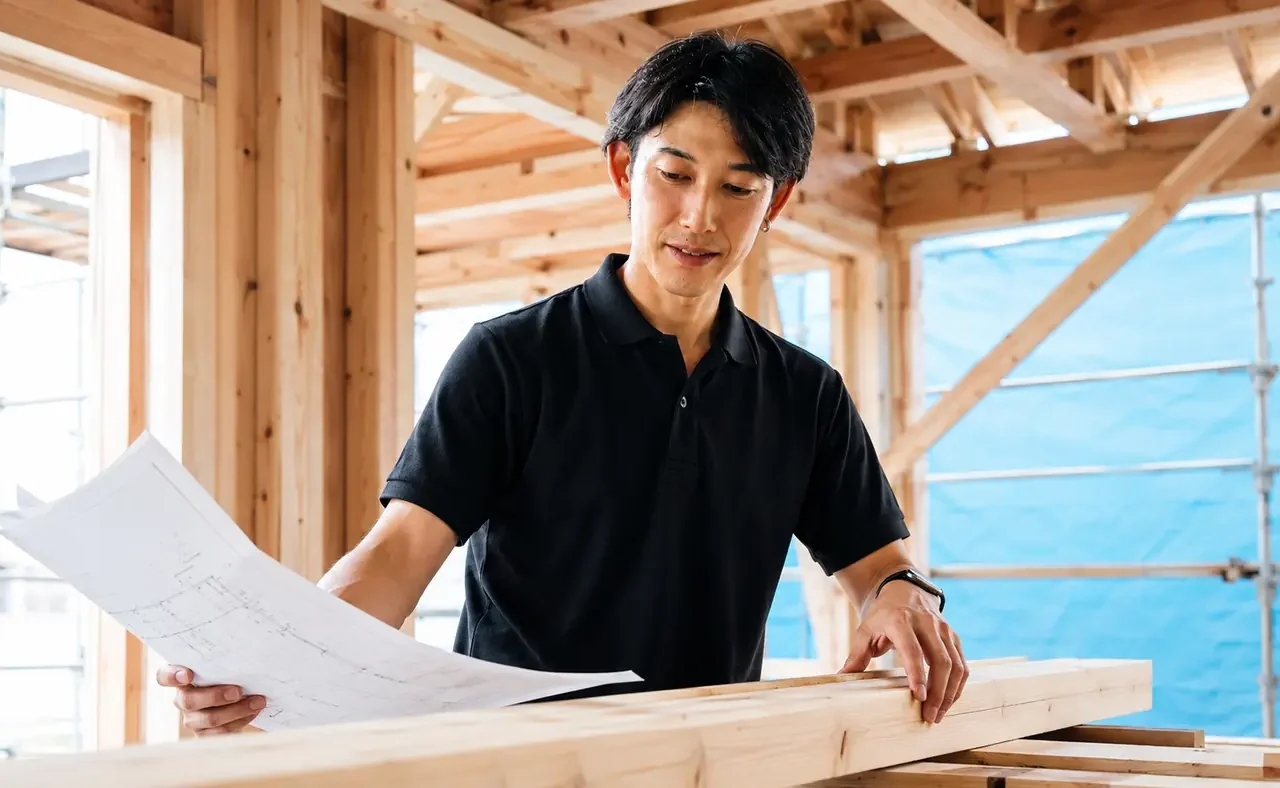 木造住宅の施工現場で図面と木材を確認するClear Linkスタッフのサービスイメージ
